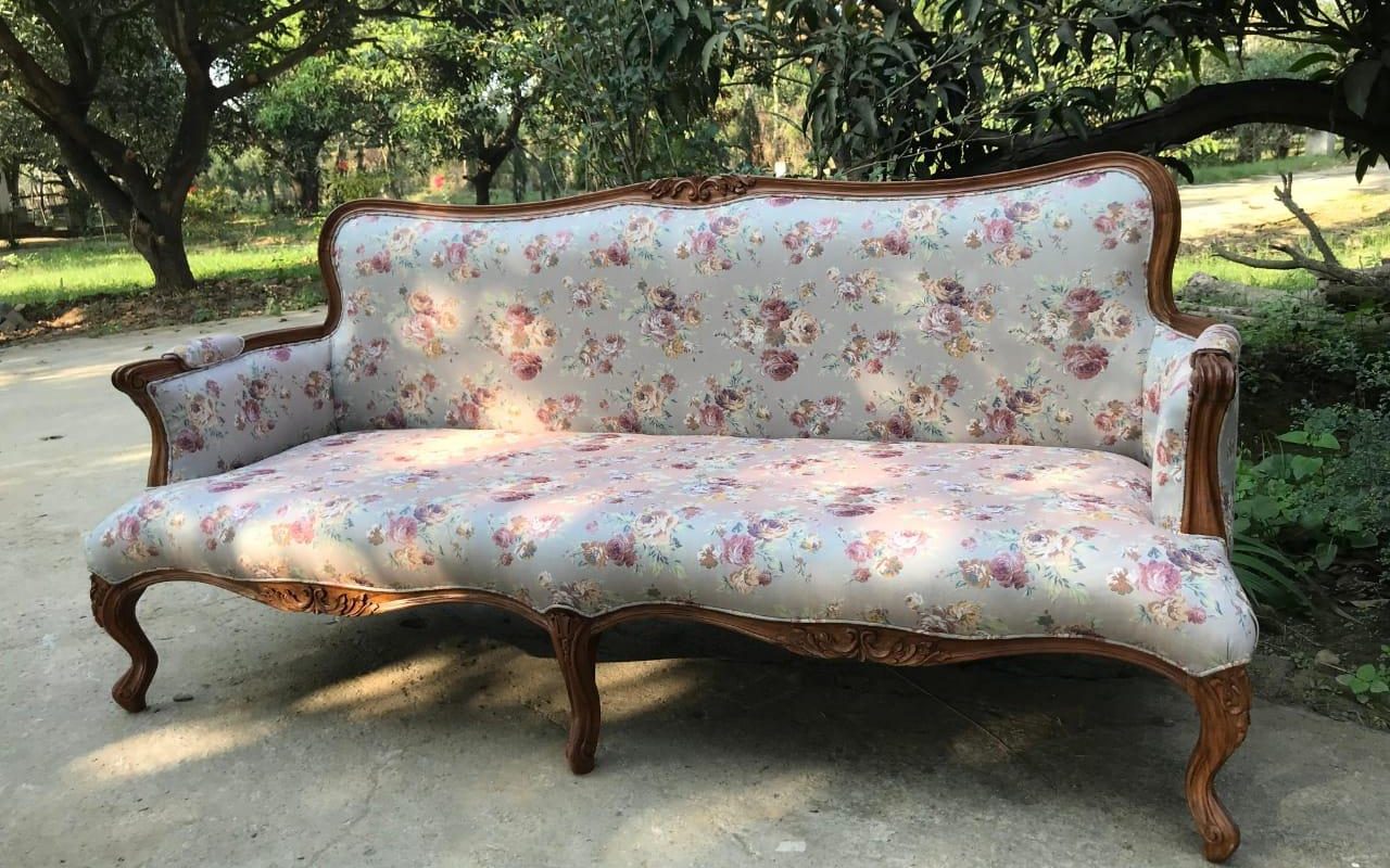 Louis XV style carved canape sofa with cabriole legs upholstered in a floral fabric